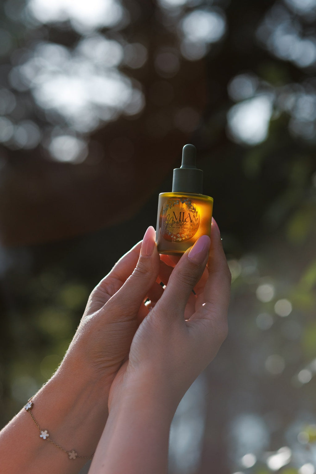 Mia Noore Radiant Glow face oil bottle held up to the light