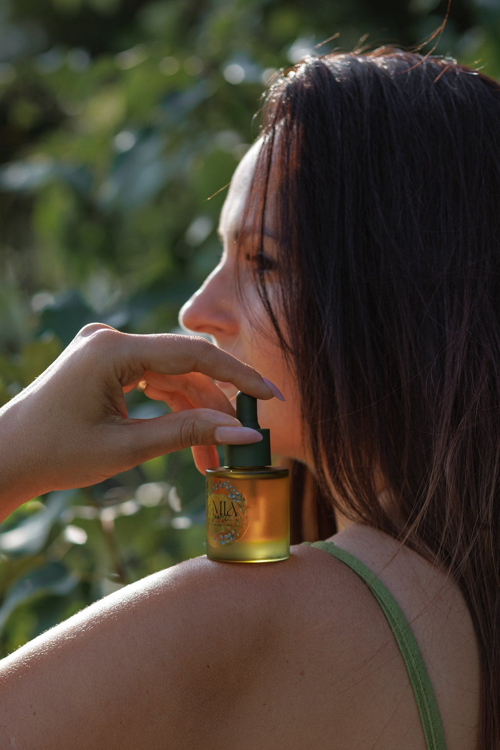 Mia Noore Radiant Glow botanical face oil bottle in hand outdoors