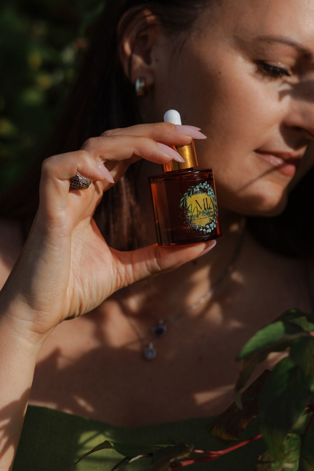 Mia Noore Timeless face oil bottle held up, amber glass with gold dropper