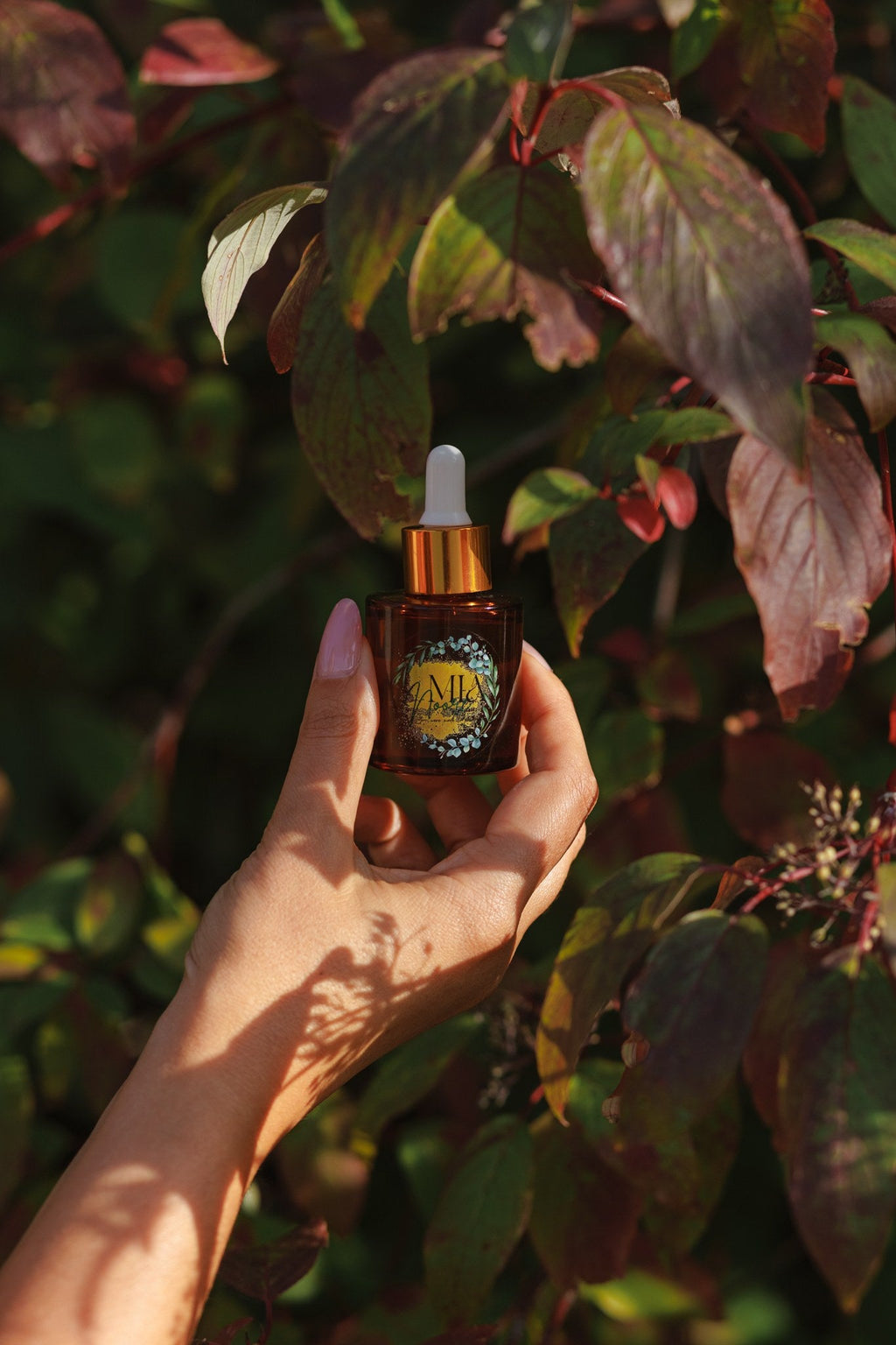 Mia Noore Timeless natural face oil bottle among autumn leaves