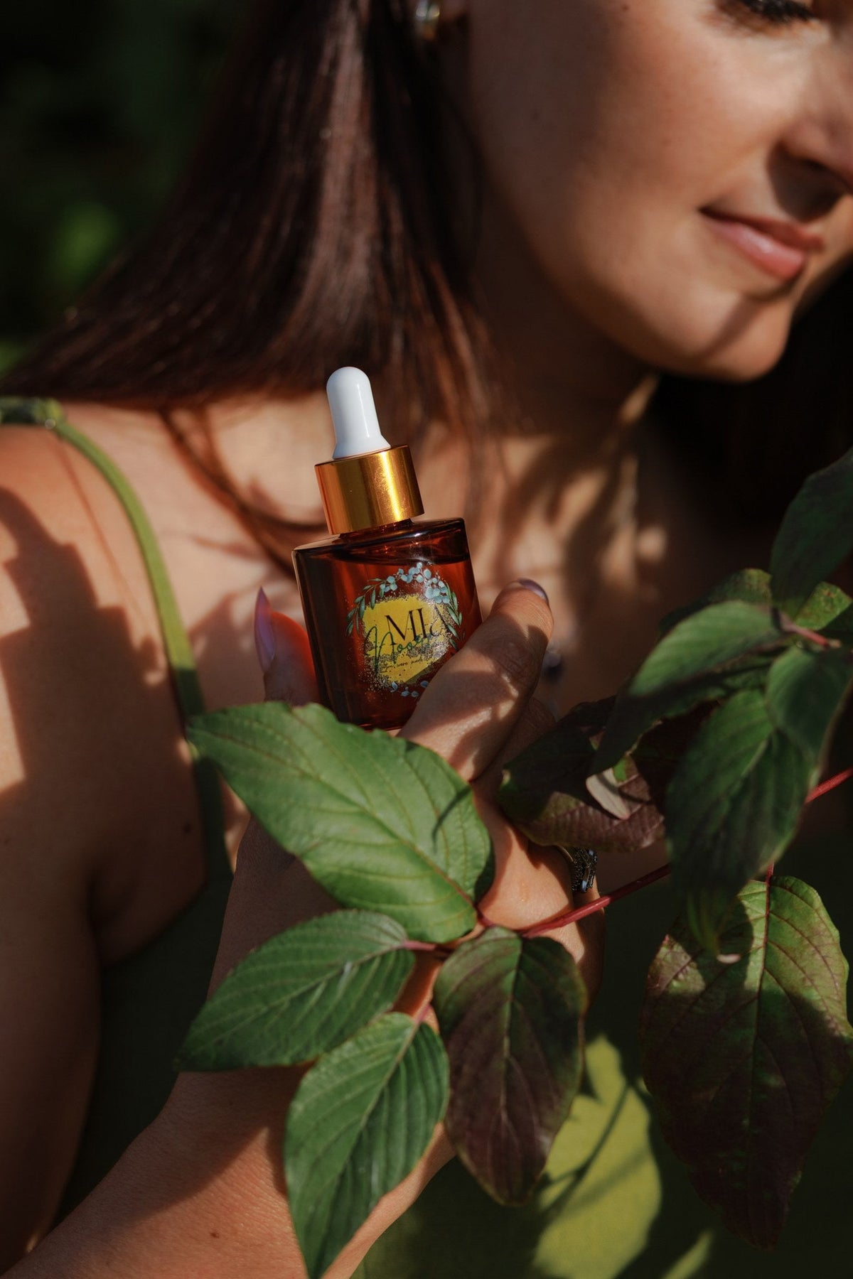 Mia Noore Timeless bakuchiol face oil held against green foliage
